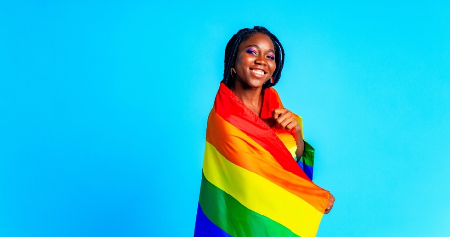 Woman with LGBTQ flag wrapped around her