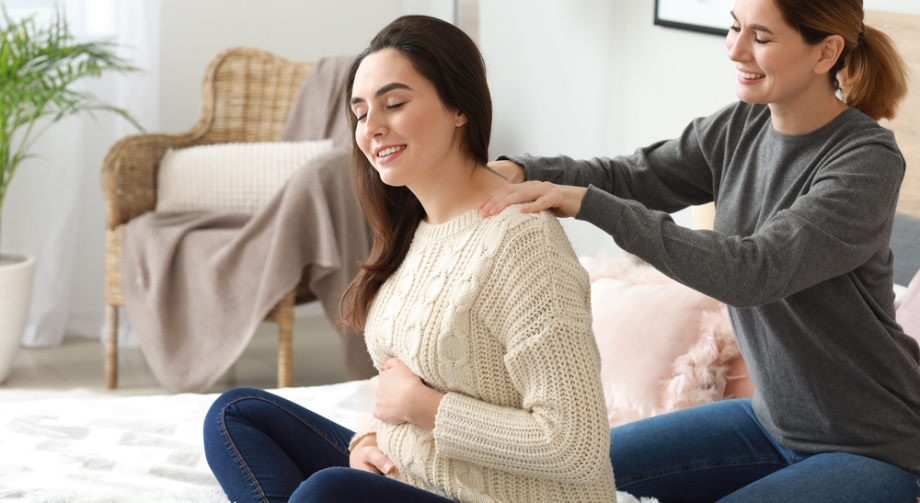 Doula giving massage to pregnant woman