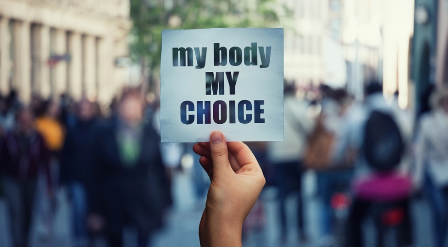 Woman holding sign in hand with my body my choice phrase