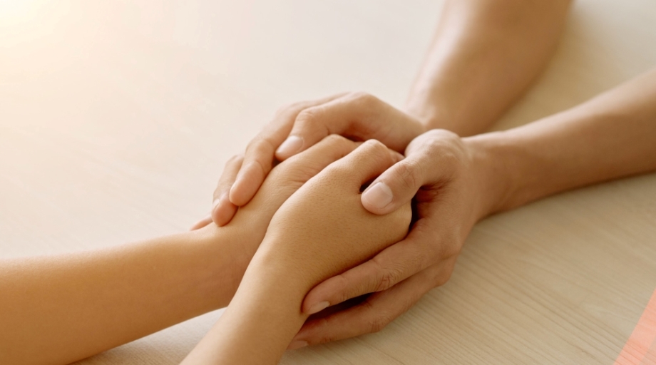 Supportive friend holding hands of woman